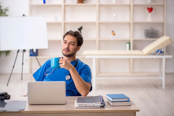 Genç erkek doktor teneffüste kahve içiyor. — Stok fotoğraf