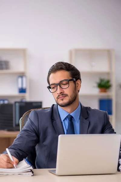 Ung manlig anställd och för mycket arbete på kontoret — Stockfoto