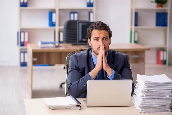 Junge männliche Mitarbeiter und zu viel Arbeit im Büro — Stockfoto