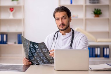 Klinikte çalışan genç bir erkek radyolog.