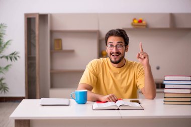 Evde sınava hazırlanan genç bir erkek öğrenci.