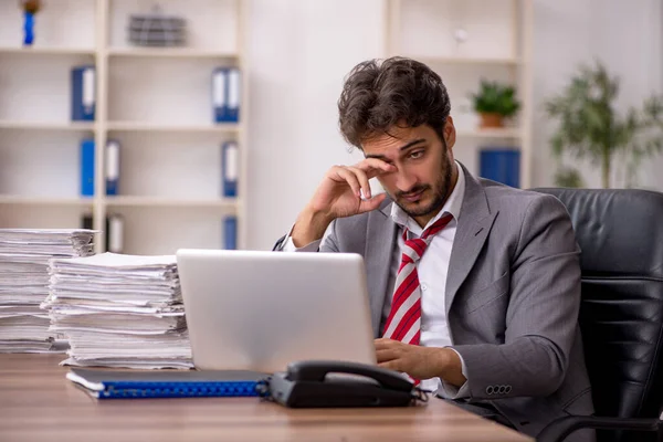 Ung manlig anställd missnöjd med överdrivet arbete på kontoret — Stockfoto