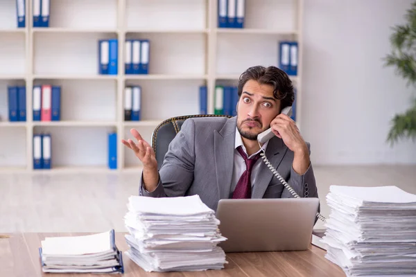 Junge männliche Mitarbeiter und zu viel Arbeit im Büro — Stockfoto