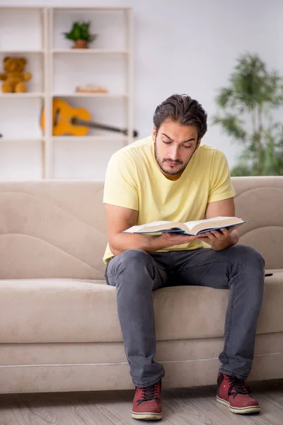 Jeune homme lisant un livre à la maison pendant une pandémie — Photo