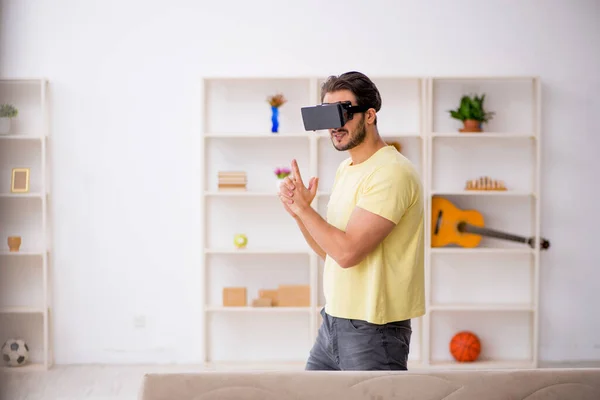 Jeune homme portant des lunettes virtuelles à la maison — Photo