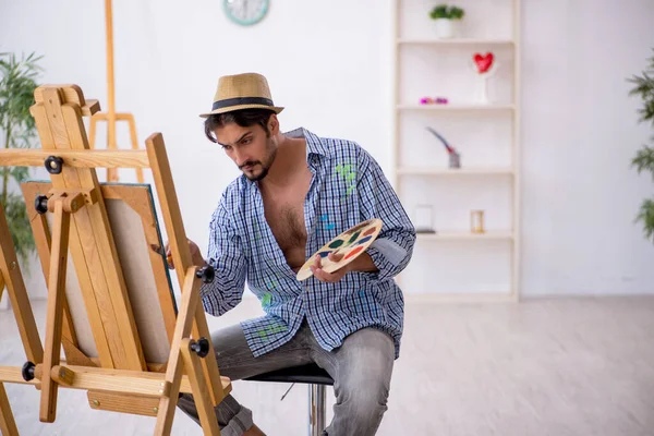 Junger Mann genießt die Malerei im Atelier — Stockfoto