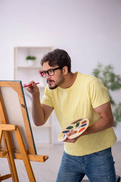 Młody człowiek cieszący się malowaniem w domu — Zdjęcie stockowe