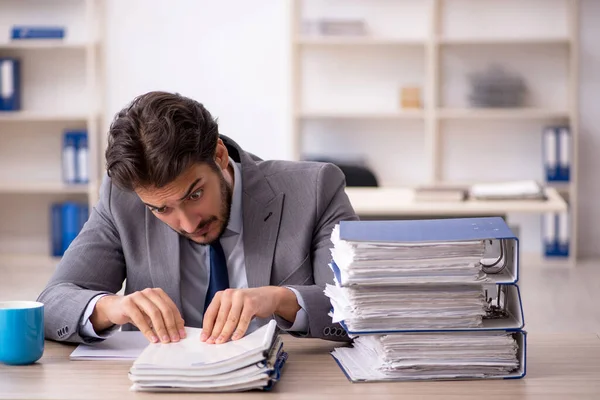 Junge männliche Mitarbeiter und zu viel Arbeit im Büro — Stockfoto