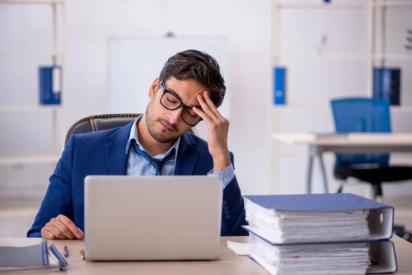 Empleado joven de negocios y demasiado trabajo en la oficina — Foto de Stock