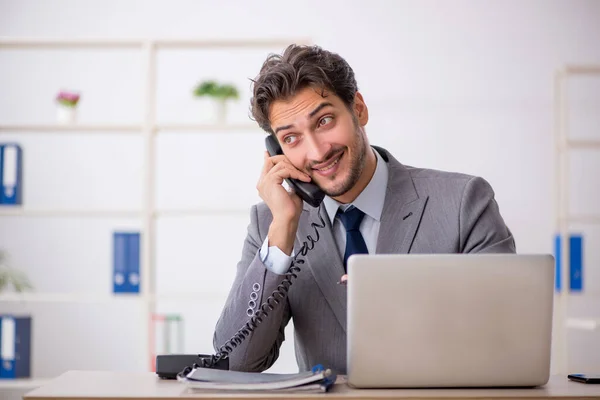 Jovem trabalhador masculino sentado no local de trabalho — Fotografia de Stock