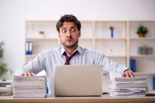 Junge männliche Mitarbeiter und zu viel Arbeit im Büro — Stockfoto