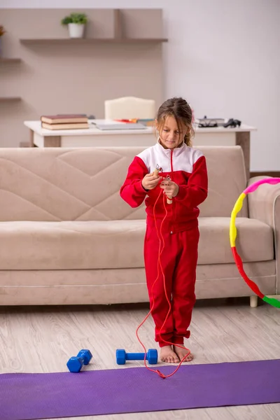 Giovane bambina che fa esercizi sportivi a casa — Foto Stock