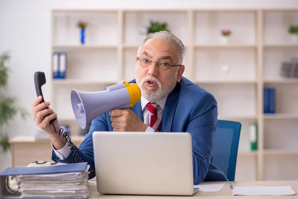 Viejo hombre de negocios enojado sosteniendo megáfono en la oficina —  Fotos de Stock