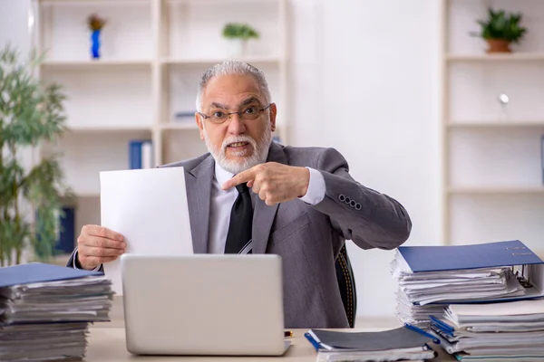 Παλιός υπάλληλος και πολλή δουλειά στο γραφείο. — Φωτογραφία Αρχείου