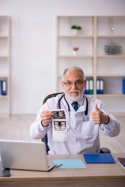 Gammal manlig röntgenläkare som arbetar på kliniken — Stockfoto