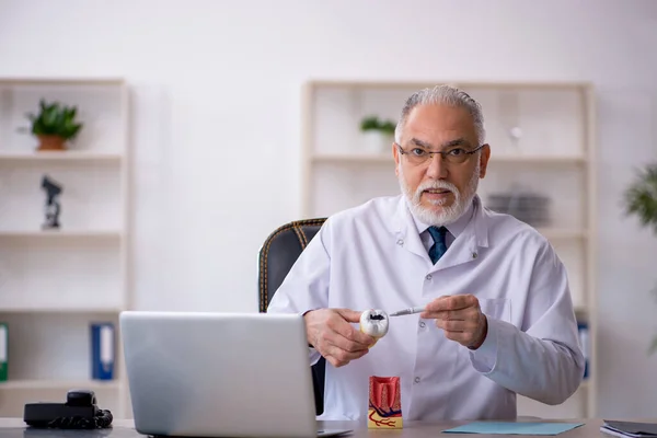 Viejo médico dentista que trabaja en la clínica — Foto de Stock