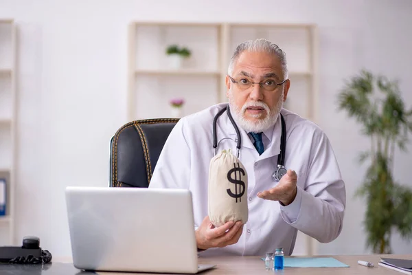 Viejo doctor en concepto de remuneración —  Fotos de Stock