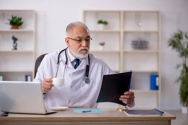 Klinikte çalışan yaşlı erkek doktor. — Stok fotoğraf