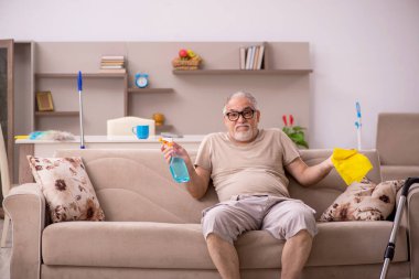 Yaşlı adam evde ev işi yapıyor.