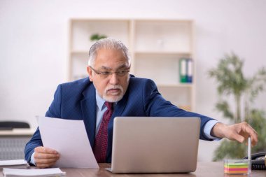 İş yerinde çalışan yaşlı bir erkek işçi.