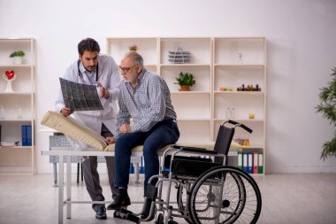 Yaşlı adam genç erkek doktor radyolojisti ziyaret ediyor.
