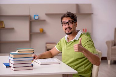 Evde okuyan genç bir erkek öğrenci.