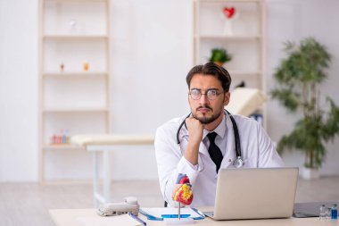 Klinikte çalışan genç bir erkek kardiyolog.