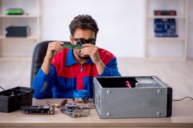 Bilgisayar tamir eden genç bir erkek tamirci.
