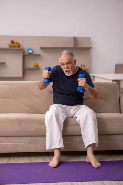 Öreg ember sporttevékenységeket végez otthon — Stock Fotó