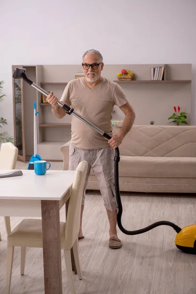 Velho fazendo tarefas domésticas em casa — Fotografia de Stock