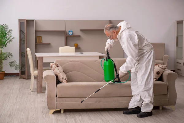 Viejo contratista masculino haciendo control de plagas en casa — Foto de Stock