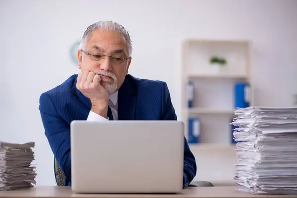 Velho empregado masculino e muito trabalho no escritório — Fotografia de Stock