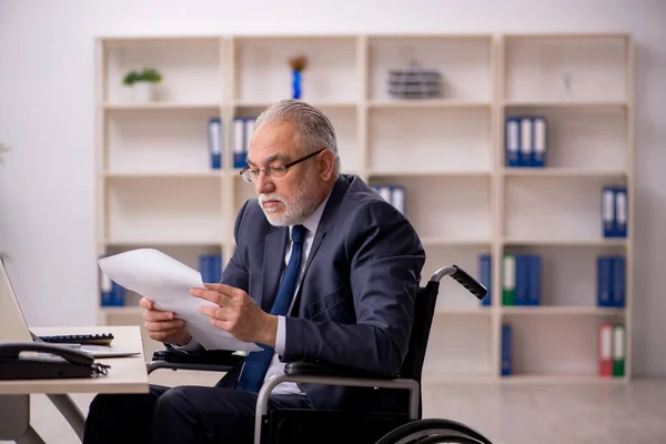 Alter männlicher Angestellter im Rollstuhl am Arbeitsplatz — Stockfoto