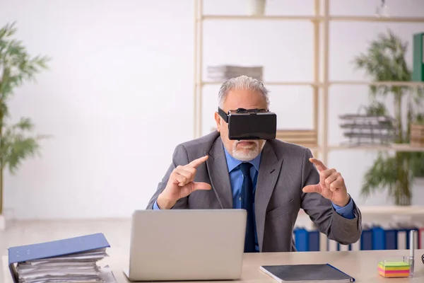 Velho funcionário do sexo masculino desfrutando de óculos virtuais no local de trabalho — Fotografia de Stock