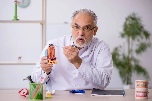 Homem velho dentista que trabalha na clínica — Fotografia de Stock