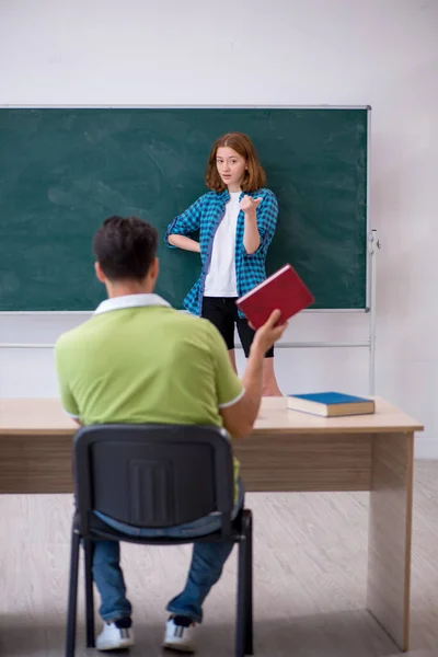 Joven profesor y estudiante en el aula — Foto de Stock