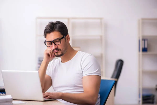 Ung manlig student anställd på arbetsplatsen — Stockfoto