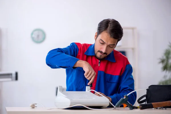 Jovem reparador do sexo masculino reparando aquecedor — Fotografia de Stock