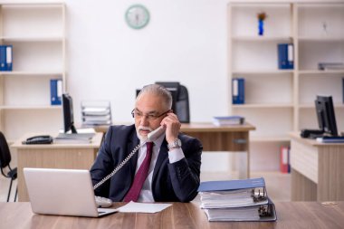 Ofiste çalışan yaşlı bir erkek.