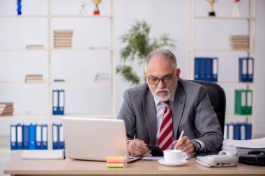 Ofiste çalışan yaşlı bir muhasebeci.
