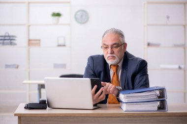 Ofiste çalışan yaşlı bir erkek işçi.