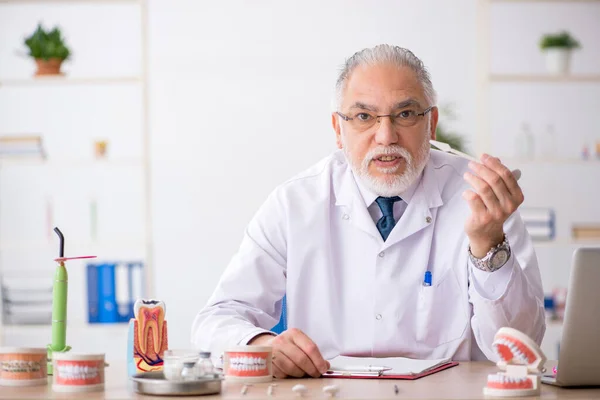 Old male doctor dentist working in the clinic — Stock Photo, Image