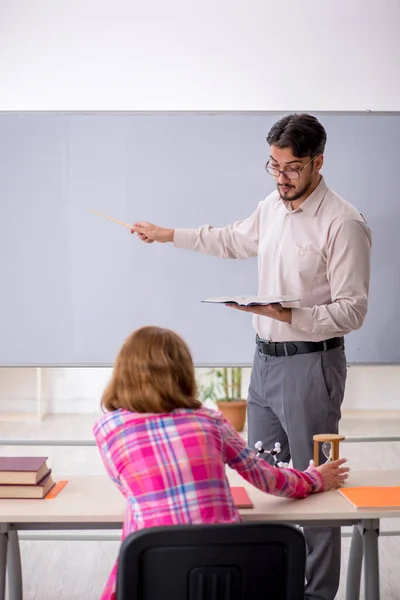 Jong man leraar en roodharige meisje in de klas — Stockfoto