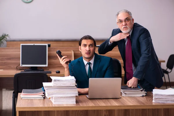 Viejo empleador masculino y joven asistente masculino en concepto de bullying —  Fotos de Stock