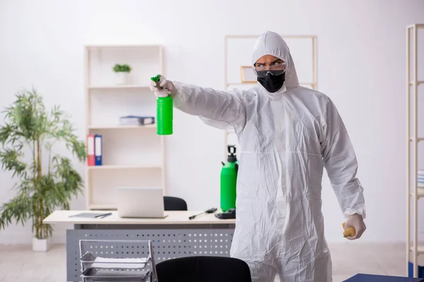 Young male contractor disinfecting office during pandemic — Stock Fotó