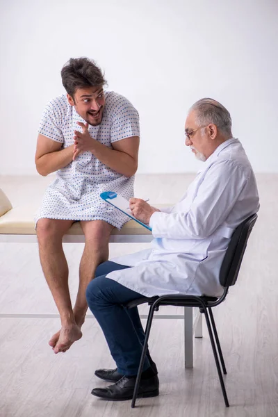 Ηλικιωμένοι άνδρες ψυχίατρος γιατρός εξέταση νεαρός άνδρας ασθενής — Φωτογραφία Αρχείου