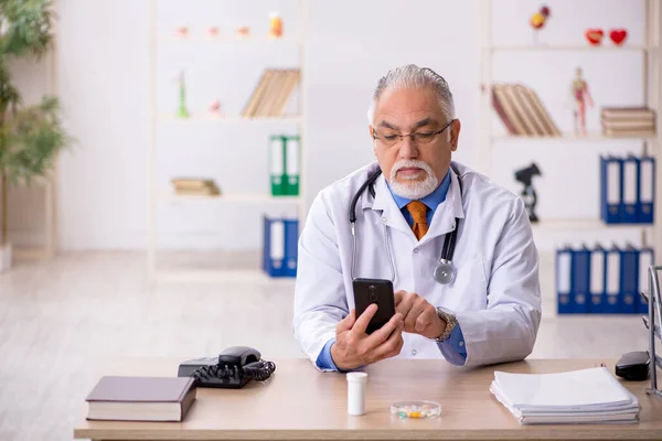 Alt männlich doktor working im die klinik — Stockfoto