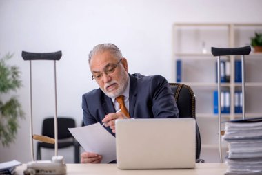 İş yerinde geçirdiği kazadan sonra yaşlı bir erkek işçi.