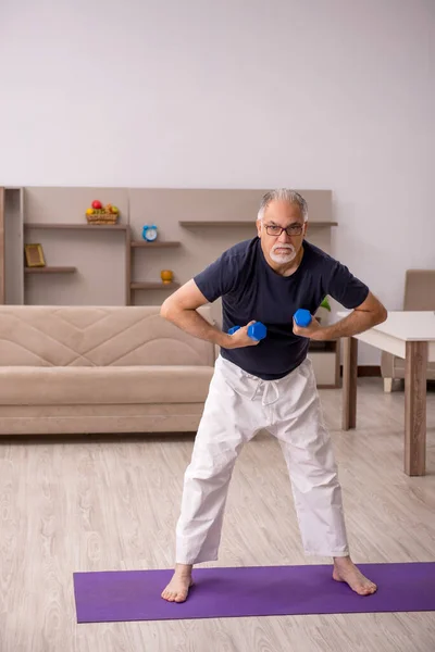 Yaşlı adam evde spor yapıyor. — Stok fotoğraf
