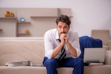 Genç erkek çalışan salgın sırasında evden çalışıyor.